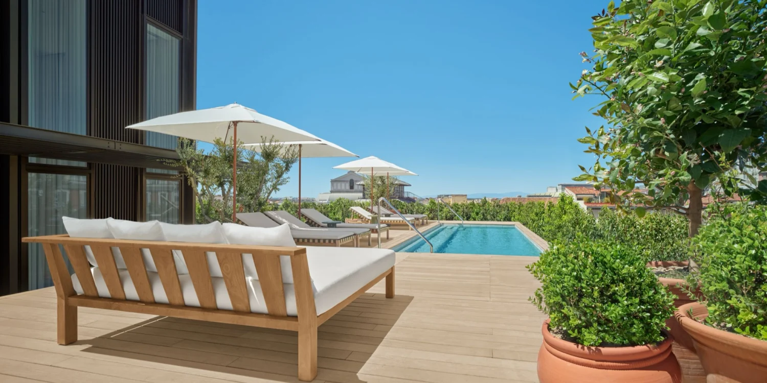 La terrasse du penthouse de The Madrid EDITION, canapé, parasol et piscine à débordement privée sur les toits de Madrid