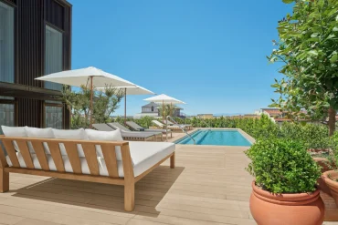 La terrasse du penthouse de The Madrid EDITION, canapé, parasol et piscine à débordement privée sur les toits de Madrid