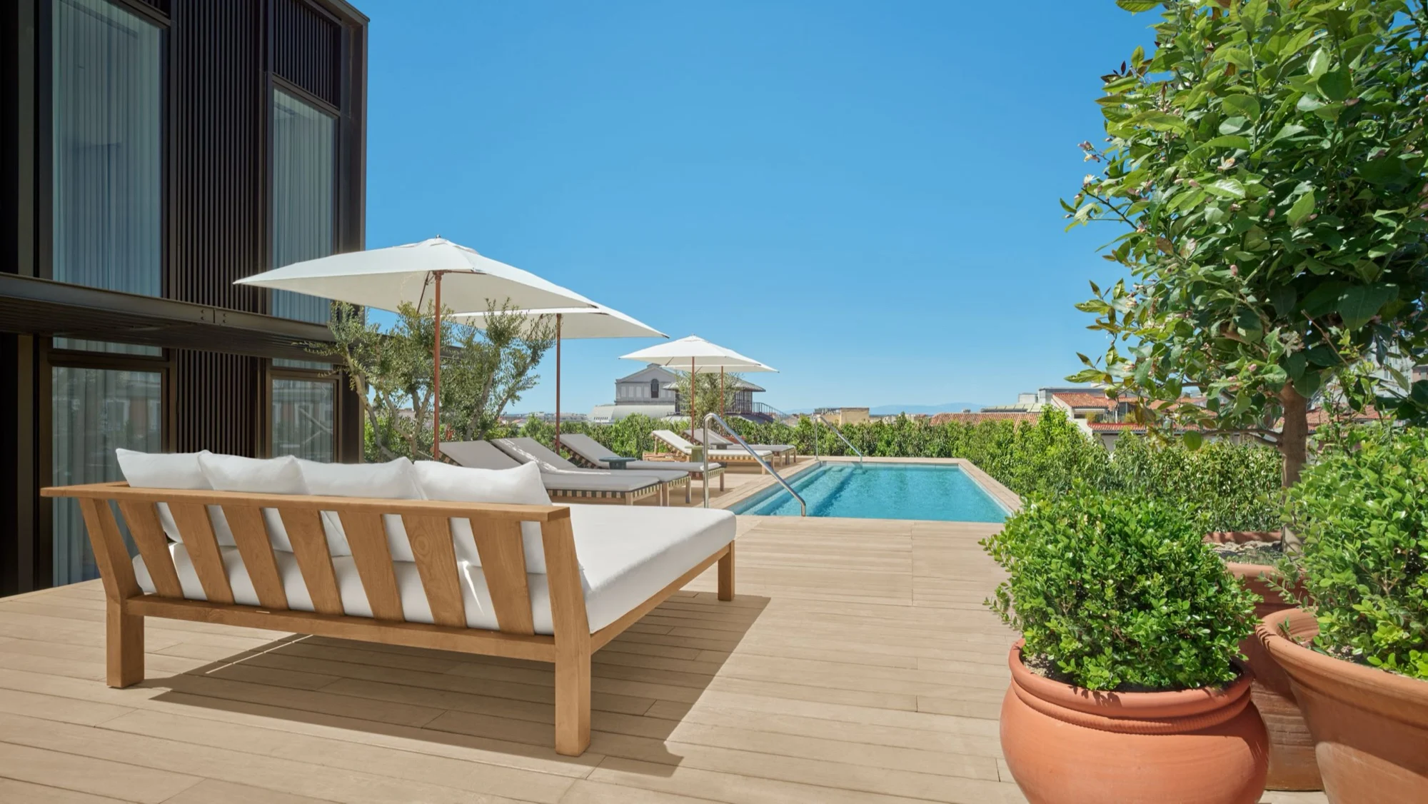 La terrasse du penthouse de The Madrid EDITION, canapé, parasol et piscine à débordement privée sur les toits de Madrid