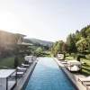 Piscine extérieure et lits de repos dans le jardin du Viktoria Alpine Hideaway à Hafling, au-dessus de Merano, face aux Alpes du Tyrol du Sud