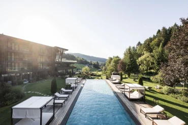 Piscine extérieure et lits de repos dans le jardin du Viktoria Alpine Hideaway à Hafling, au-dessus de Merano, face aux Alpes du Tyrol du Sud