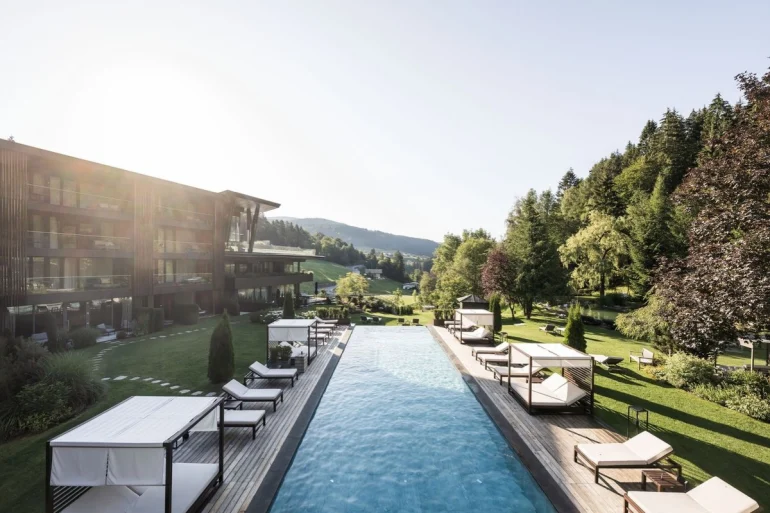 Piscine extérieure et lits de repos dans le jardin du Viktoria Alpine Hideaway à Hafling, au-dessus de Merano, face aux Alpes du Tyrol du Sud