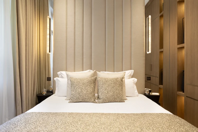 Une chambre d'appartement Airbnb à Paris, lit fait et grands rideaux : défaire le lit au départ ne pourra plus être exigé à partir du 20 novembre 2026