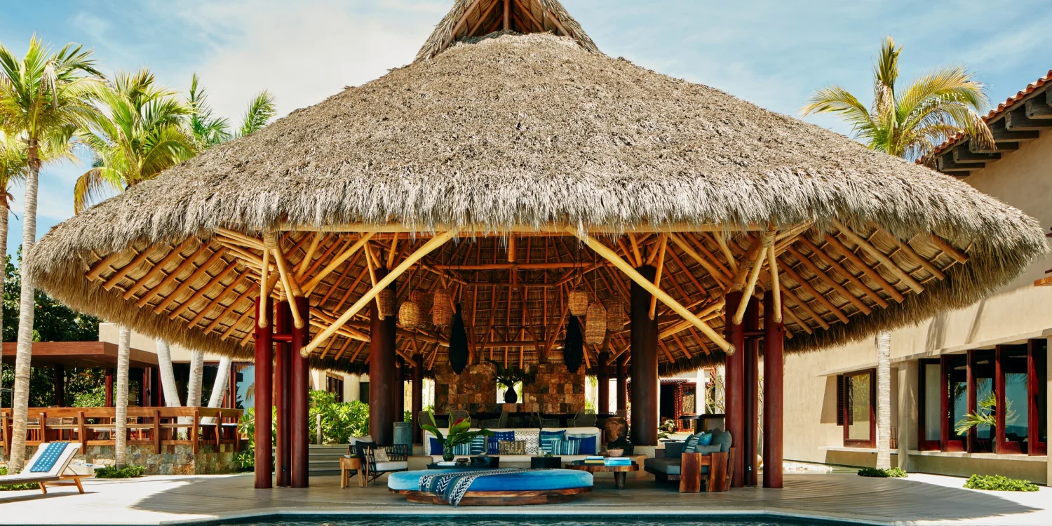 Le grand salon sous toit de palmes et la piscine de Casa Koko, villa Airbnb Luxe de Punta Mita, au Mexique