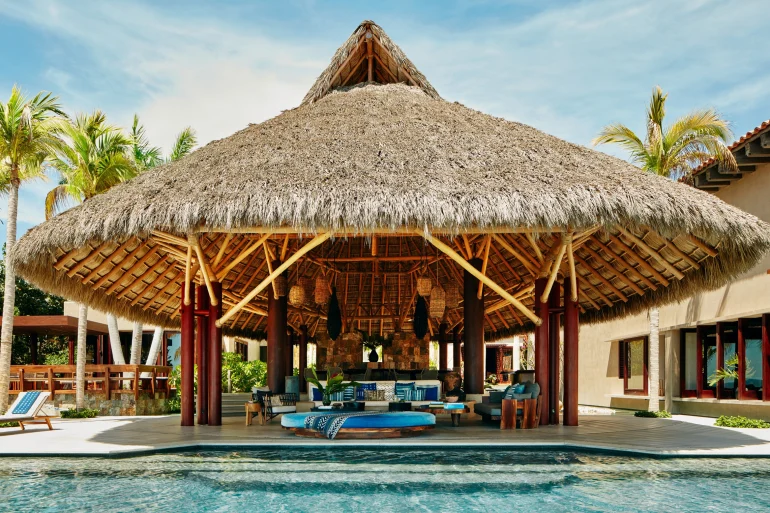 Le grand salon sous toit de palmes et la piscine de Casa Koko, villa Airbnb Luxe de Punta Mita, au Mexique