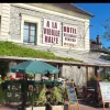 Façade de l'hôtel À la Vieille Halle à Souppes-sur-Loing, avec son enseigne et sa terrasse fleurie