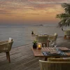 La terrasse du restaurant Cumin de l'Anantara Veli Maldives Resort face au lagon au coucher du soleil