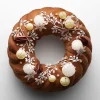 La Bûche de Noël Couronne 2026 du Mandarin Oriental Lutetia, Paris, couronne torsadée ornée de grelots en chocolat blanc et de feuilles d'azyme