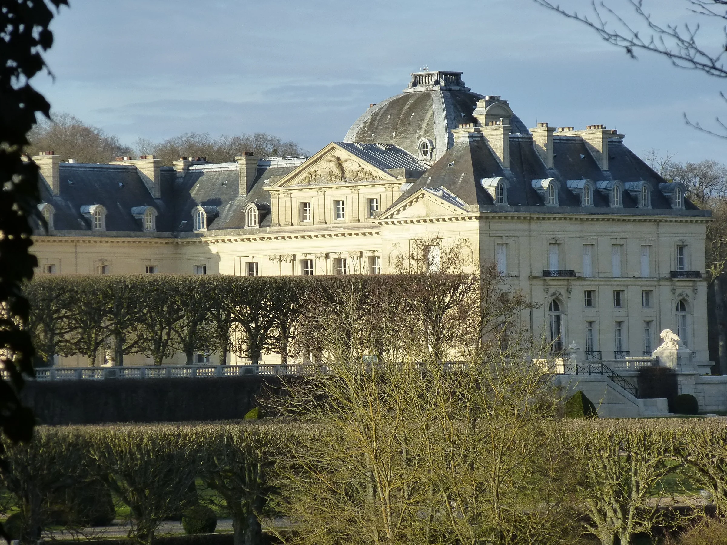 Façade du château de Voisins à Saint-Hilarion (Yvelines) vue depuis le parc, avec ses toits d'ardoise et son dôme