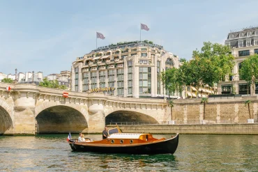 Bateau en bois sur la Seine devant le Pont-Neuf et la façade de Cheval Blanc Paris