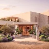 Rendu de l'entrée du futur Delano Puglia à Monopoli, façade en pierre claire, jardin méditerranéen et oliviers