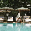 La piscine du Copacabana Palace à Rio de Janeiro, transats et parasols sous les arbres