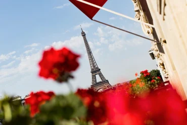 Les géraniums rouges de l'Hôtel Plaza Athénée, palace Dorchester Collection de l'avenue Montaigne, avec la tour Eiffel en arrière-plan