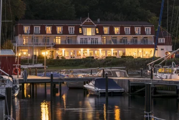 Le Boutique Hotel Wassersleben au crépuscule, façade éclairée au bord du port de plaisance sur la Flensburger Förde