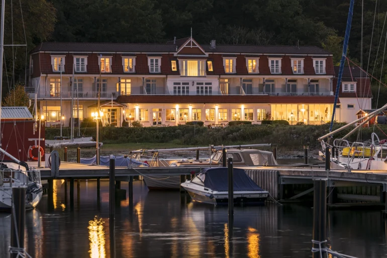Le Boutique Hotel Wassersleben au crépuscule, façade éclairée au bord du port de plaisance sur la Flensburger Förde