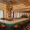 Le Lobby Bar du Fairmont New Orleans, son comptoir vert et son lustre en laiton