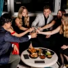 Des clients trinquent autour d'une table basse au Mile High Cocktail Club du Four Seasons Hotel Chicago