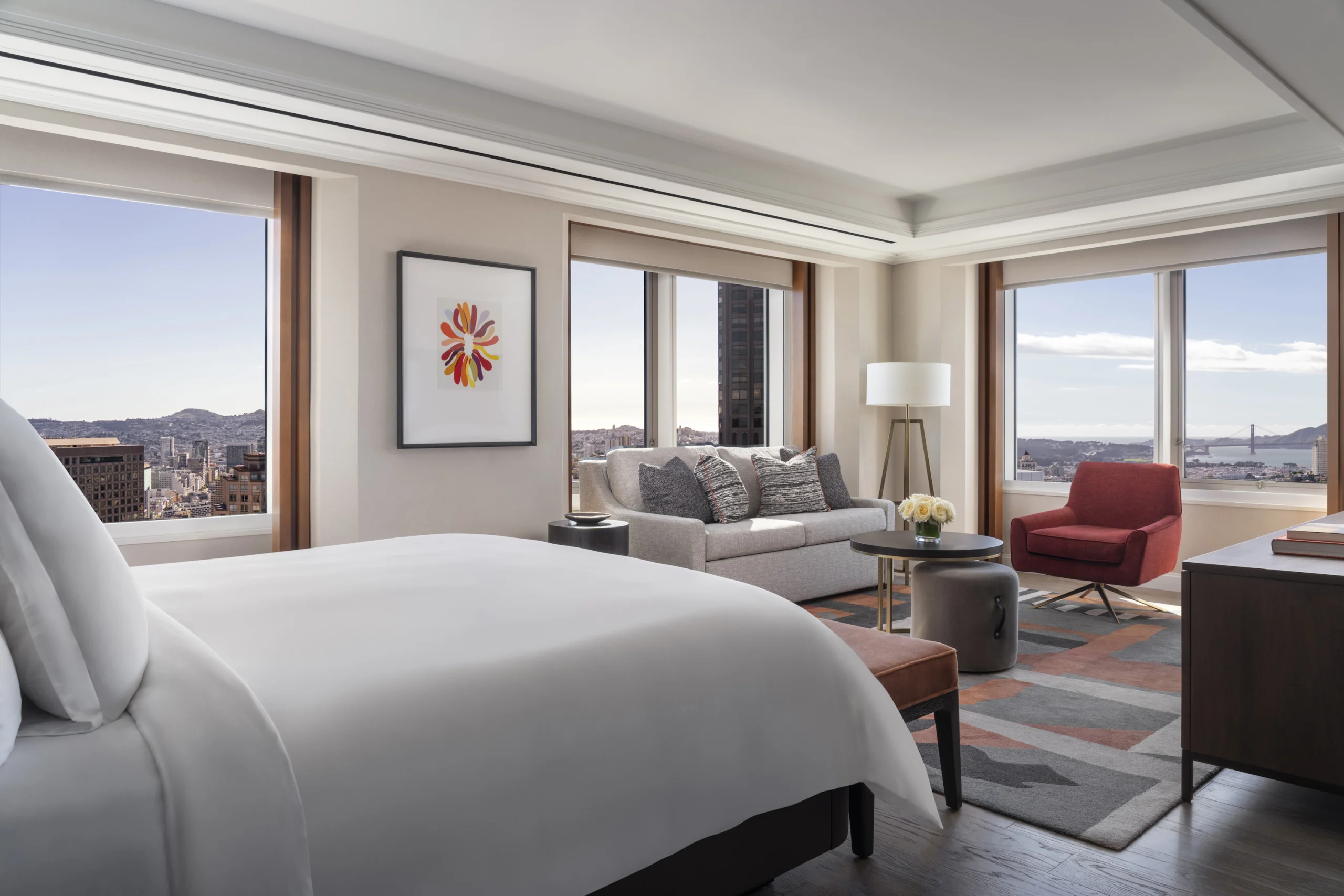 Chambre de la Landmark Suite du Four Seasons Hotel San Francisco at Embarcadero, lit king size et coin salon face aux baies vitrées sur la ville et la baie