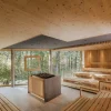 Les gradins en bois clair du Quell-Sauna, ouverts sur la forêt, au Heilthermen Resort de Bad Waltersdorf