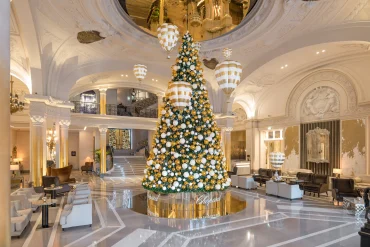 Le lobby de l'Hôtel de Paris Monte-Carlo à Noël, grand sapin doré sous la coupole et sols de marbre