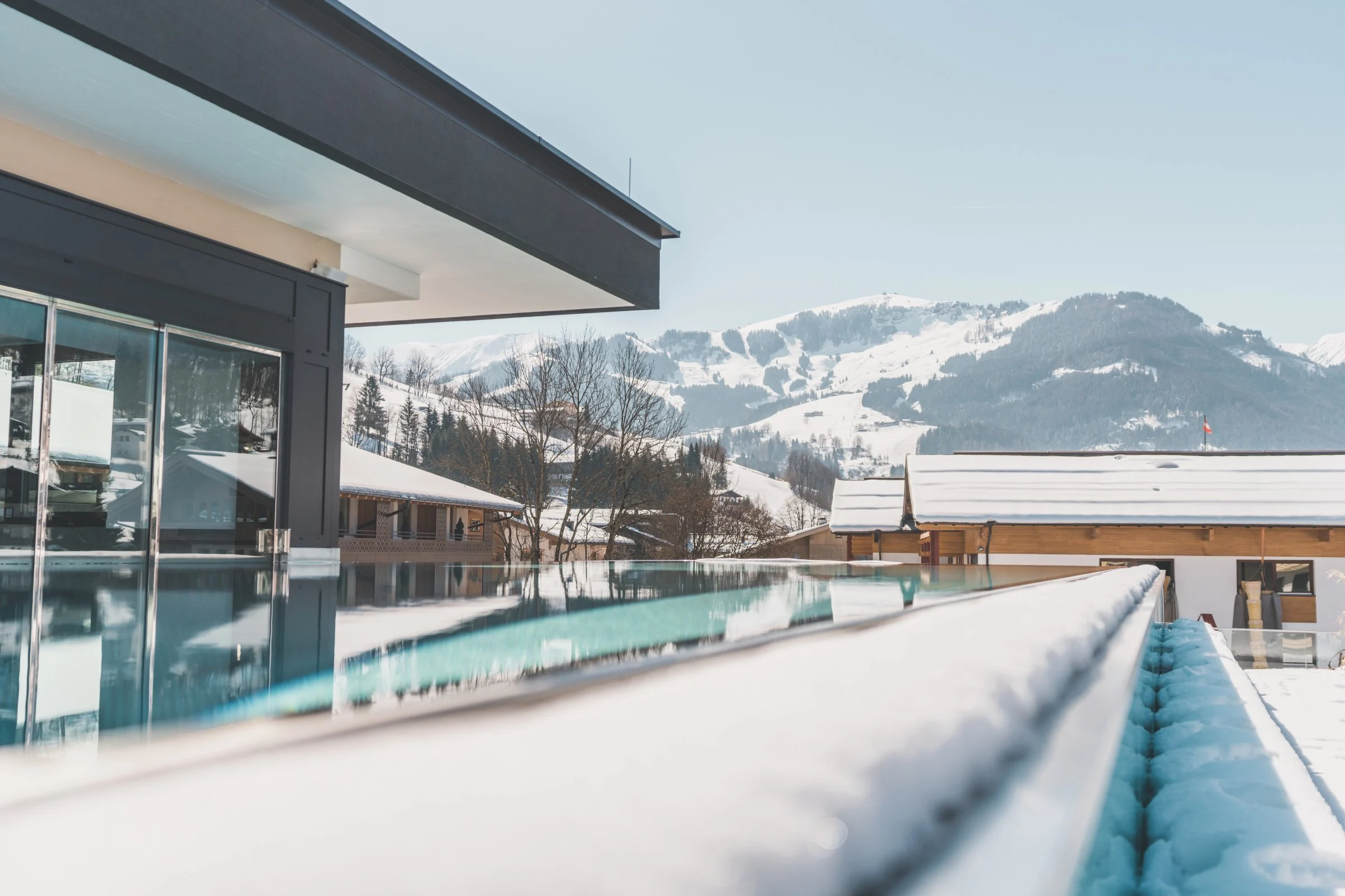 La piscine à débordement de l'hôtel Die Hochkönigin face aux sommets enneigés de Maria Alm