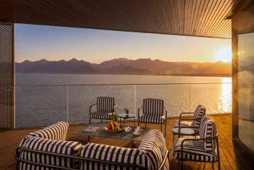 Terrasse de la Talya Royal Suite au coucher du soleil, salon de jardin rayé face à la baie d'Antalya et aux monts Beydağları