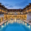 La piscine thermale extérieure de l'Ensana Fürstenhof à la tombée du jour, entre les ailes de l'hôtel à Bad Griesbach