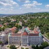 Vue aérienne de l'hôtel Gellért à Budapest, ses coupoles vertes et la colline Gellért boisée derrière