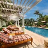 Piscine extérieure bordée de palmiers et pergola fleurie de l'hôtel Hemingways Nairobi, à Karen