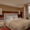 Chambre d'une Executive Suite du Graal Cortina, laque rouge, lit king size et fenêtre ouverte sur les Dolomites