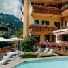 La façade de l'hôtel Le Lyret à Chamonix, balcons fleuris, jardin et piscine extérieure