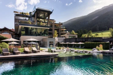 Façade de l'hôtel Lürzerhof à Untertauern avec ses deux nouveaux étages, le Sky Pool en porte-à-faux et le lac de baignade naturel