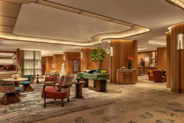 Lobby du premier étage de l'hôtel Mandarin Oriental The Landmark à Hong Kong, redessiné par Joyce Wang dans des tons terre cuite et vert profond