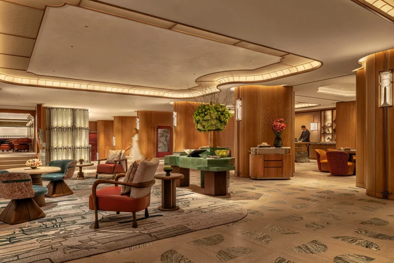 Lobby du premier étage de l'hôtel Mandarin Oriental The Landmark à Hong Kong, redessiné par Joyce Wang dans des tons terre cuite et vert profond