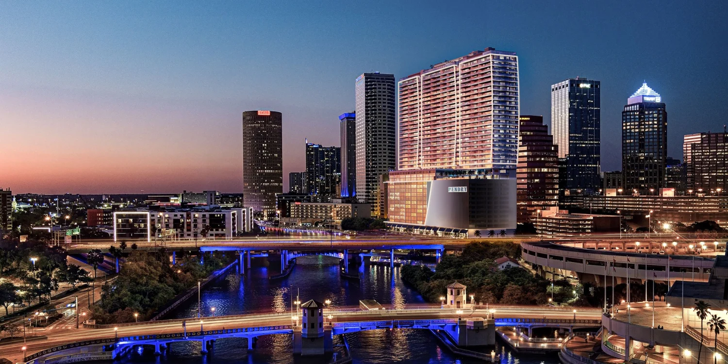 Rendu de la tour Pendry Tampa illuminée au crépuscule au bord de la rivière Hillsborough, à Tampa