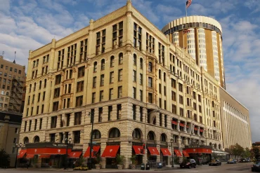 Façade néo-romane de The Pfister Hotel à Milwaukee avec sa tour ronde et ses auvents rouges