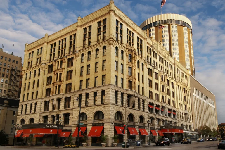 Façade néo-romane de The Pfister Hotel à Milwaukee avec sa tour ronde et ses auvents rouges