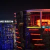 La tour de l'hôtel REM illuminée de rouge la nuit, à City of Dreams Macao, avec la piscine transparente de The Lair à son sommet