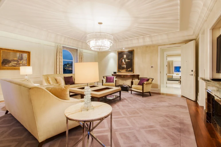 Salon de la Royal Suite du Ritz-Carlton Montréal, canapés crème, lustre en cristal et toiles anciennes