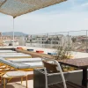 Transats jaunes et voile d'ombrage sur le toit-terrasse de l'hôtel Ruby Lilou, face aux toits de Marseille et aux collines