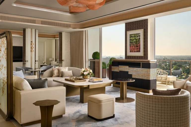 Le salon de la suite présidentielle de 335 m² du St. Regis Singapore, ouvert sur un balcon et la verdure de Tanglin