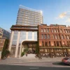 Rendu de la façade de l'hôtel The Ann sur Ann Street à Belfast, avec la tour vitrée et le bâtiment classé Jamison and Green restauré