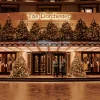 La façade de l'hôtel The Dorchester sur Park Lane à Londres, illuminée de sapins de Noël, avec deux portiers en livrée