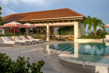 La piscine sur le toit de The Nora Hotel à West Palm Beach, transats blancs et parasols roses à festons