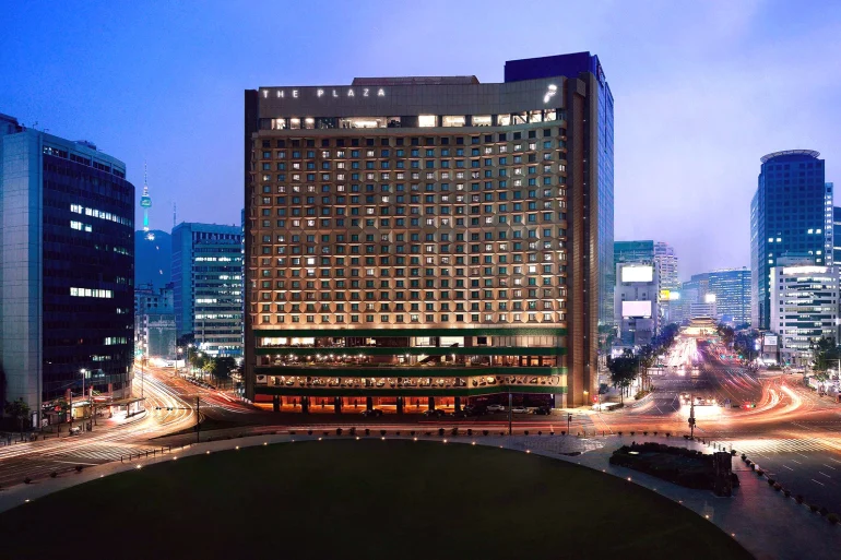 La façade de l'hôtel The Plaza à Séoul, de nuit, face à la Seoul Plaza et à l'hôtel de ville