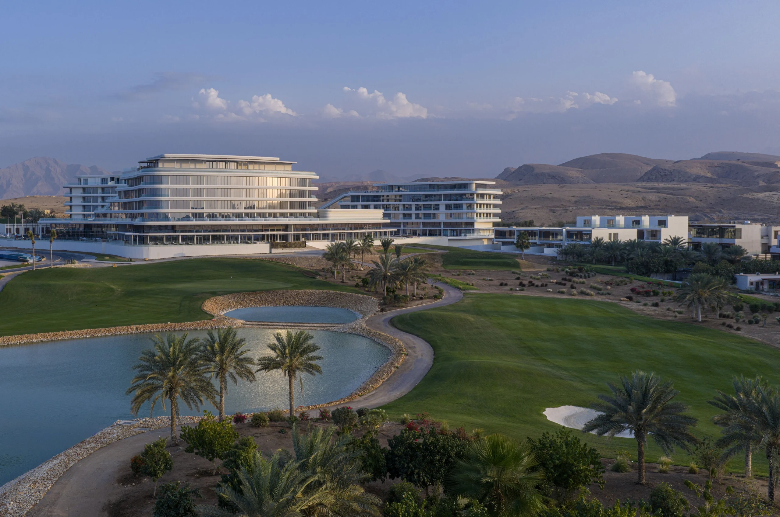 Le Tivoli LA VIE Muscat Hotel & Residences au bord du golf du LA VIE Country Club, monts Hajar en arrière-plan, à Mascate