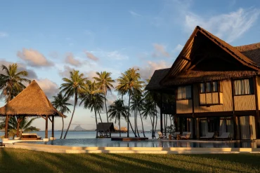 La villa royale Ari'i Vahine du Vahine Private Island au coucher du soleil, piscine et silhouette de Bora Bora à l'horizon