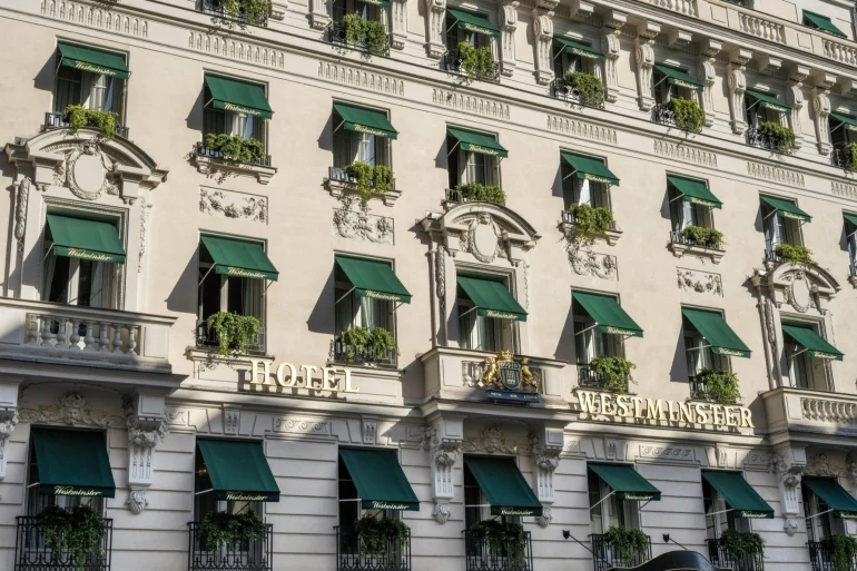 Façade de l'hôtel Westminster rue de la Paix à Paris, stores verts, balcons fleuris et enseigne dorée
