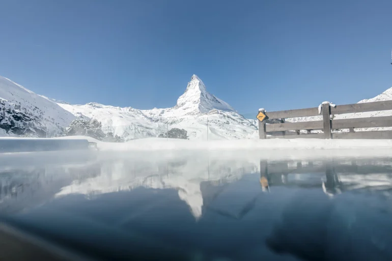La piscine extérieure chauffée du Riffelalp Resort 2222m, fumante dans le froid, face au Cervin enneigé au-dessus de Zermatt