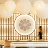Le comptoir omakase du restaurant KANJIRU, lanternes de papier et claustra de bois, à l'hôtel Torel Private Collection de Porto